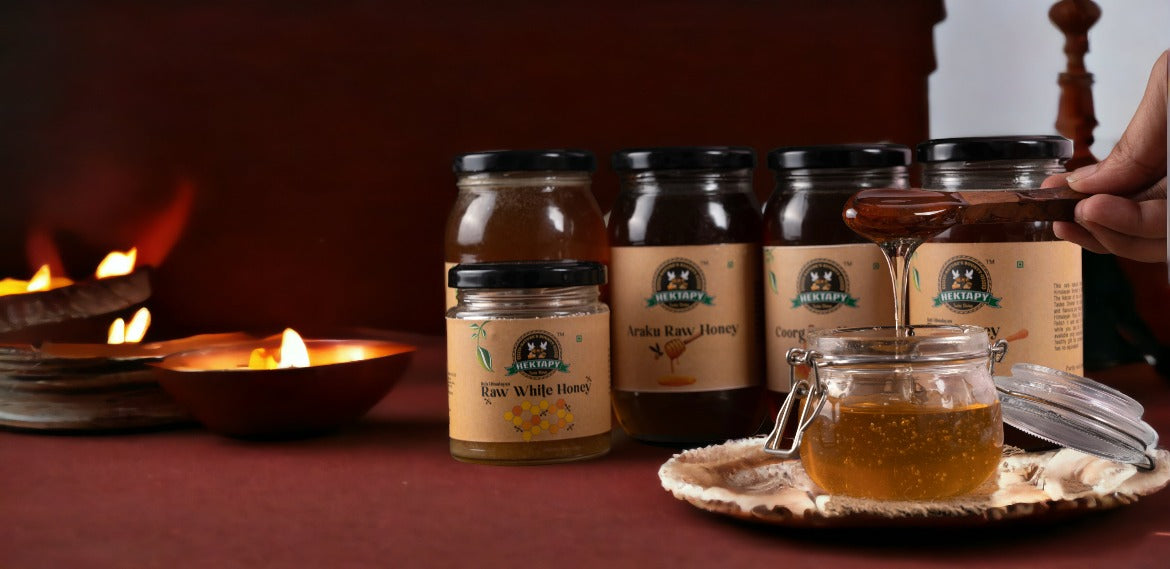 Hektapy Raw Wild Honey in a glass jar with a honey dipper and whole grain cracker